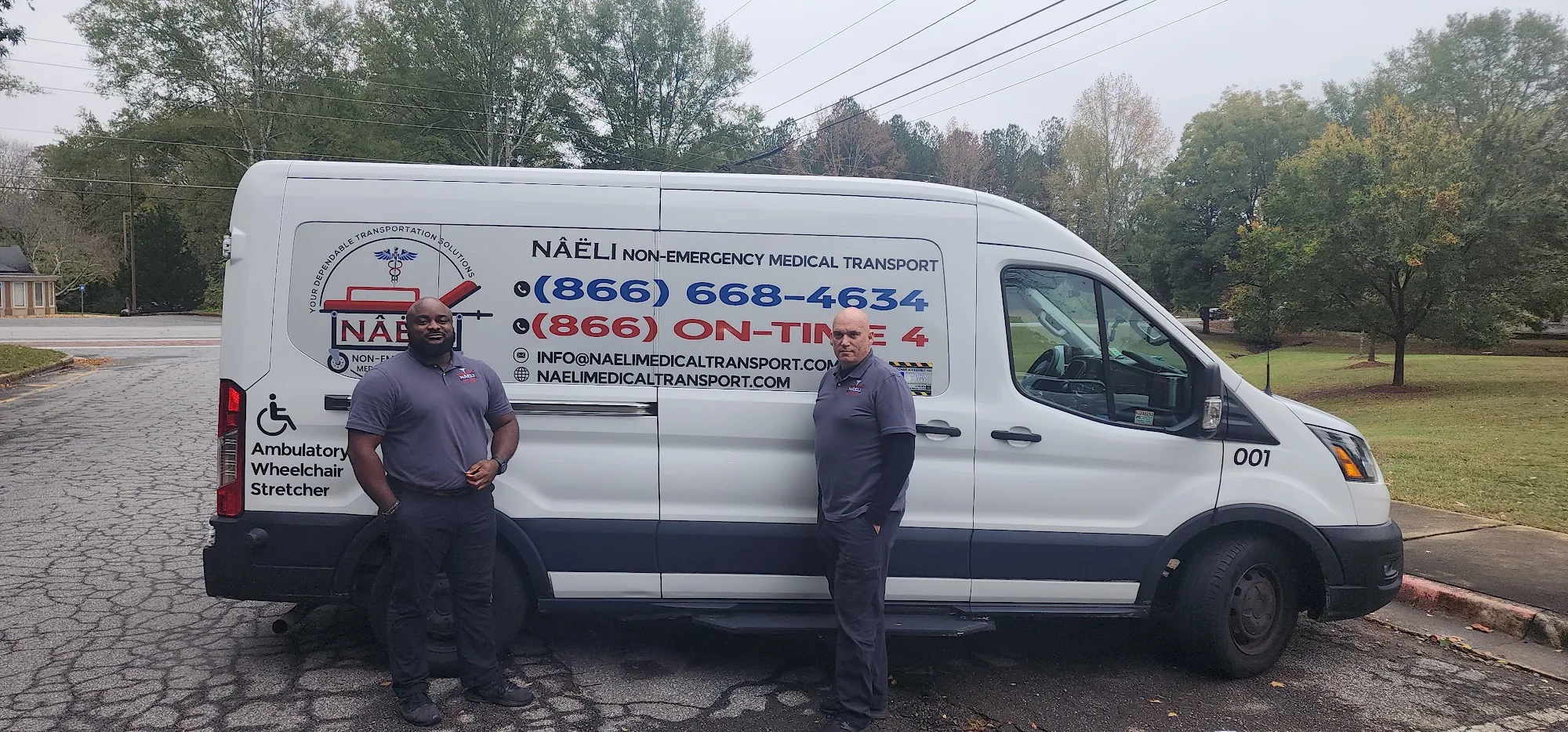 Two members of the Naeli Medical Transport team standing in front of a company van